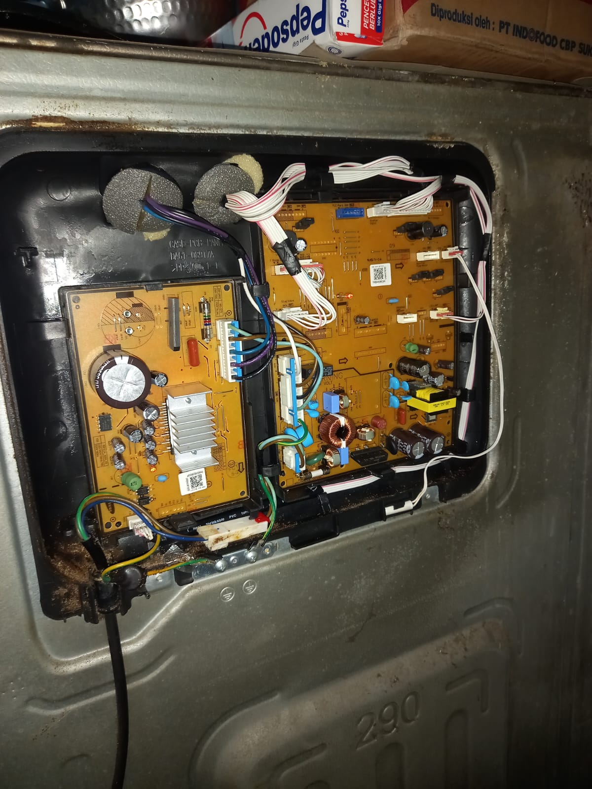 Technician testing electrical connections on a washing machine circuit board with multimeter, focused on diagnosing faults